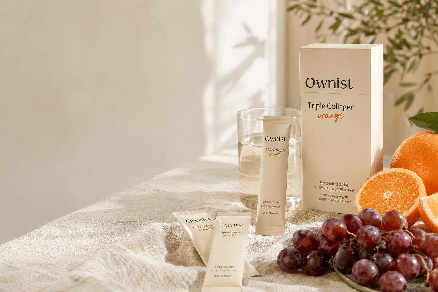 Ownist daily sachets with orange and grape ingredients on a clean surface